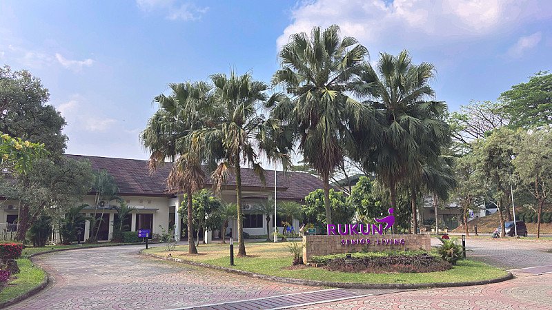 Front view of RUKUN Senior Living with gardens and palm trees